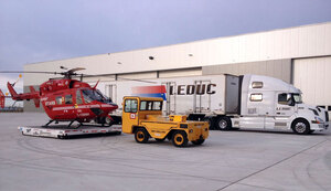 A Stars Air Ambulance helicopter rests on a steel skid awaiting loading onto a Leduc Truck Service semi unit.